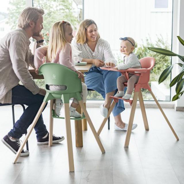 familia usando la silla Stokke Clikk y la trona con beb&eacute;s de diferentes edades